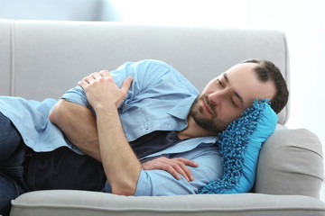 Wall Mural - Handsome depressed man lying on sofa at home