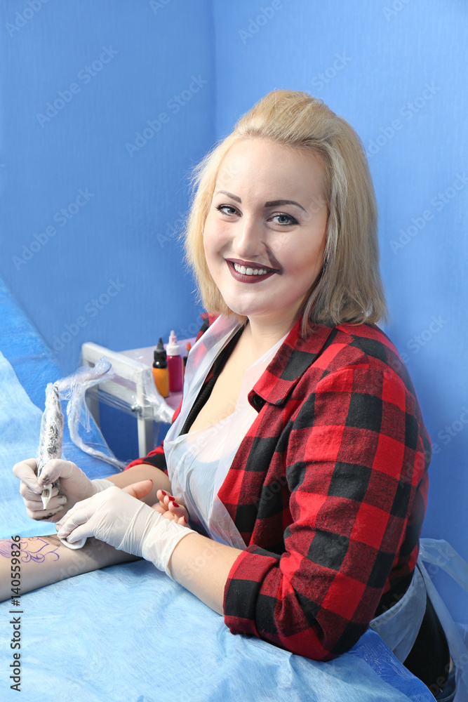 Master making tattoo in salon
