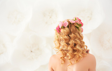 Wall Mural - Beautiful young woman with flowers in hair on light background