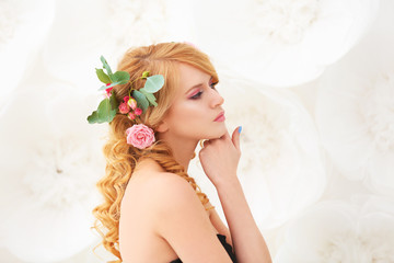 Wall Mural - Beautiful young woman with flowers in hair on light background