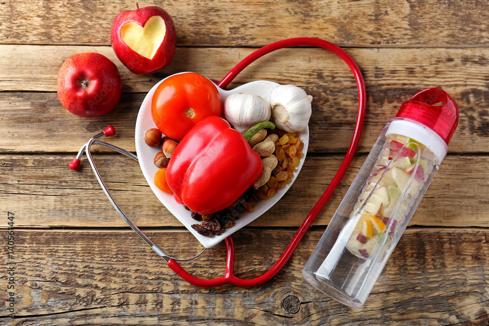 Healthy food and stethoscope on wooden background