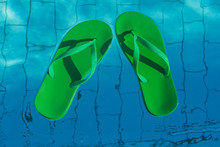 Green Flip Flops Floating In The Swimming Pool, Top View