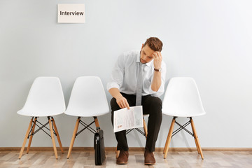 Canvas Print - Young man waiting for interview indoors