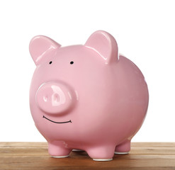 Wall Mural - Pink piggy bank on wooden table against white background