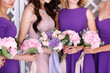 the bride and bridesmaids in violet dresses with bouquets in hands. Morning of the bride, wedding day