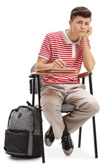 Wall Mural - Bored teenage student sitting in a chair