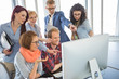 © moodboard - Group of smiling businesspeople using computer together in office