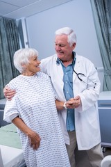 Sticker - Doctor assisting senior patient at hospital