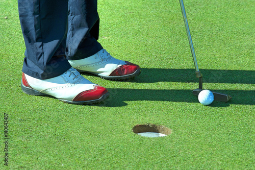 Plakat Zakończenie up osoby kładzenia piłka golfowa na polu golfowym
