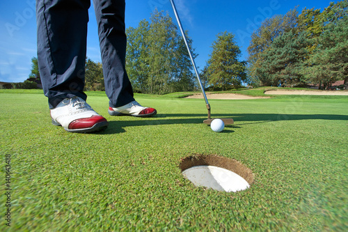 Plakat Zakończenie up osoby kładzenia piłka golfowa na polu golfowym