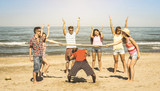 Fototapeta  - Multiracial happy friends group having fun together with limbo game at beach - Summer joy and friendship concept with young multi ethnic people playing on spring break vacation - Retro vintage filter