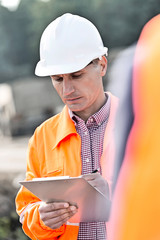 Wall Mural - Supervisor writing on clipboard at construction site