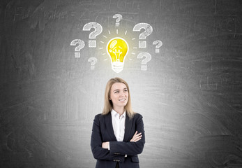 Wall Mural - Smiling blond woman, light bulb and questions