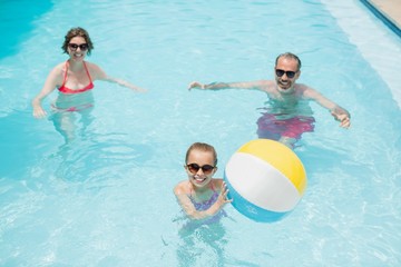 parents and daughter playing with swim ball