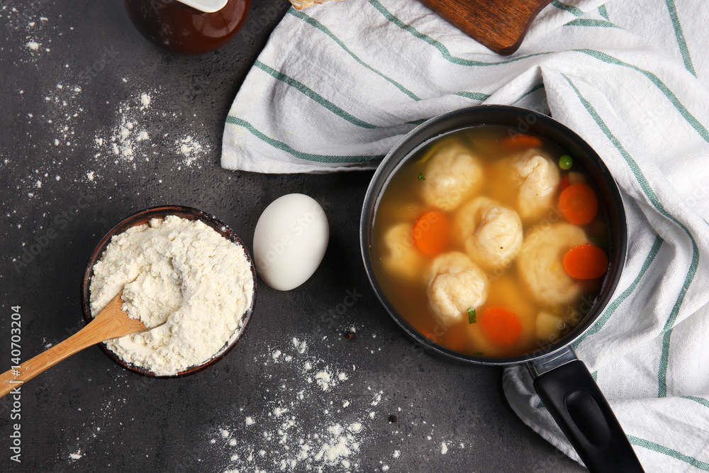 Stewpan with delicious chicken and dumplings on kitchen table