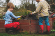 © RooM The Agency - Two boys playing with mud in garden
