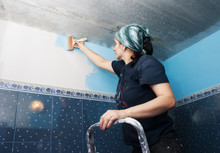 Woman Painting A Wall In The Bathroom