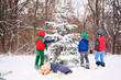 © RooM The Agency - Three children decorating a Christmas tree in the garden with their golden retriever dog
