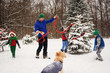 © RooM The Agency - Father and three children decorating a Christmas tree in the garden with golden retriever dog watching