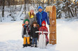 © RooM The Agency - Portrait of a family standing in snow with a sledge