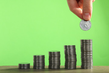 hand puts a coin on a tower of coins