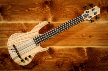 Wall Mural - micro bass guitar on wooden background