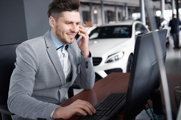 Car dealer on the phone talking with client .