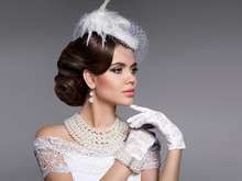 Retro Woman Portrait. Elegant Lady With Hairstyle, Pearls Jewelry Set Wears In Hat And Lace Gloves Posing Isolated On Studio Gray Background.