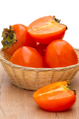 Wall Mural - Ripe persimmons in a wicker bowl