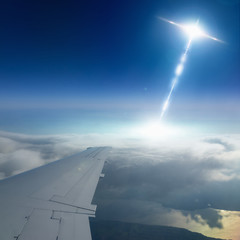 Wall Mural - ufo flies near airplane in dark blue sky