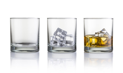 Empty glass, glass with ice cubes and glass with whiskey and ice cubes. Isolated on white background