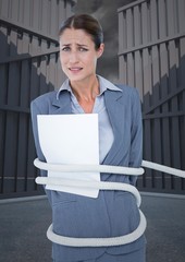 Wall Mural - Portrait of tense businesswoman tied up with rope and paper