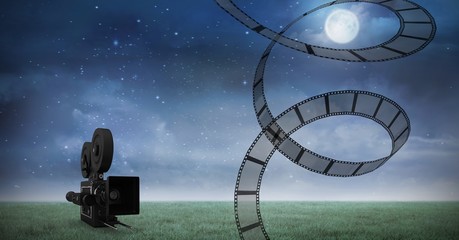 Wall Mural - Film reel against video camera and night sky in background