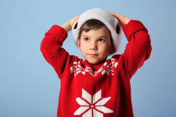 Wall Mural - Cute little boy in warm clothes on color background