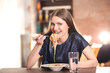 © Africa Studio - Beautiful woman eating pasta on table against blurred background
