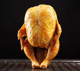 Canvas Print - Marinaded chicken on beer can against black background