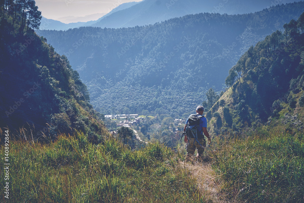 Hiker walking on the trail in the green mountains in Nepal Stock Photo ...