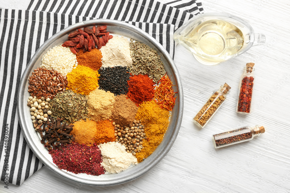 Tray with mix of different spices on wooden table