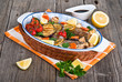 seabass fish baked with vegetables, herbs and lemon