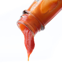 Tomato Ketchup Falling From Bottle On White Background
