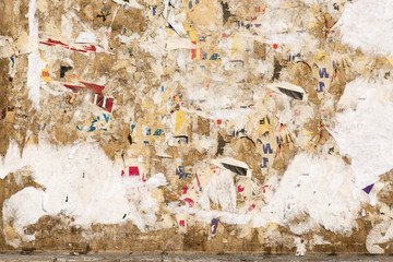 Colorful torn posters on grunge old walls, large background, texture