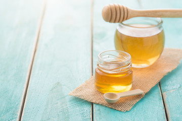 Wall Mural - Honey with wooden honey dipper on blue wooden table