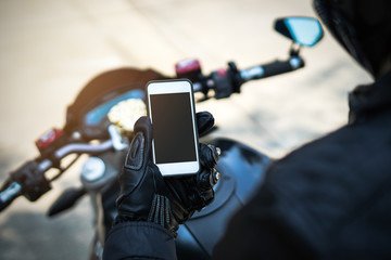 biker riding motorbike and holding smart phone