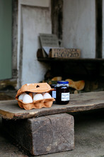 Eggs And Homemade Jam For Sale On The Porch Of A House In Small Village Of Lacock, England. Buyer Are Asked To Pay For Products Into Honesty Box.