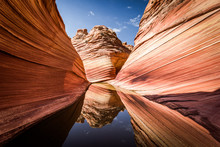 Arizona - Utah Border, A Stunning Rock Formation Known As The Wave In The Rocky Desert, Reflecting On A Rare Water Puddle