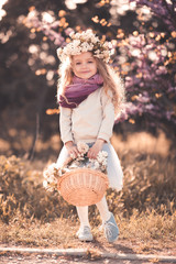 Wall Mural - Happy kid girl 5-6 year old wearing casual clothes outdoors. Holding flower basket. Looking at camera. Childhood.