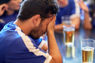 close up of sad football fan at bar or pub