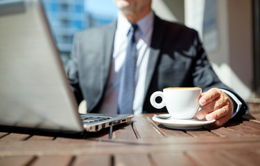 Poster - senior businessman with laptop and coffee outdoors