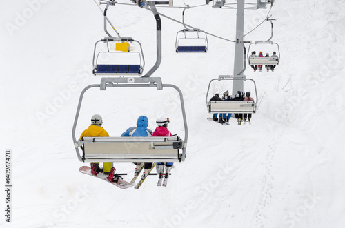 A chair lift transports skiers and snowboarders up a slope in a ski resort Tableau sur Toile