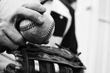 Old baseball in hand of a man who plays the sport.  Great ball game or athletic background or print.